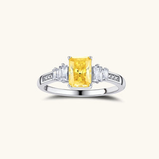 Yellow moissanite jewelry set with emerald-cut stones in sterling silver halo settings on white background.